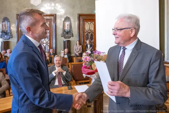 Uroczystość wręczenia nagrody z gratulacjami i kwiatami.