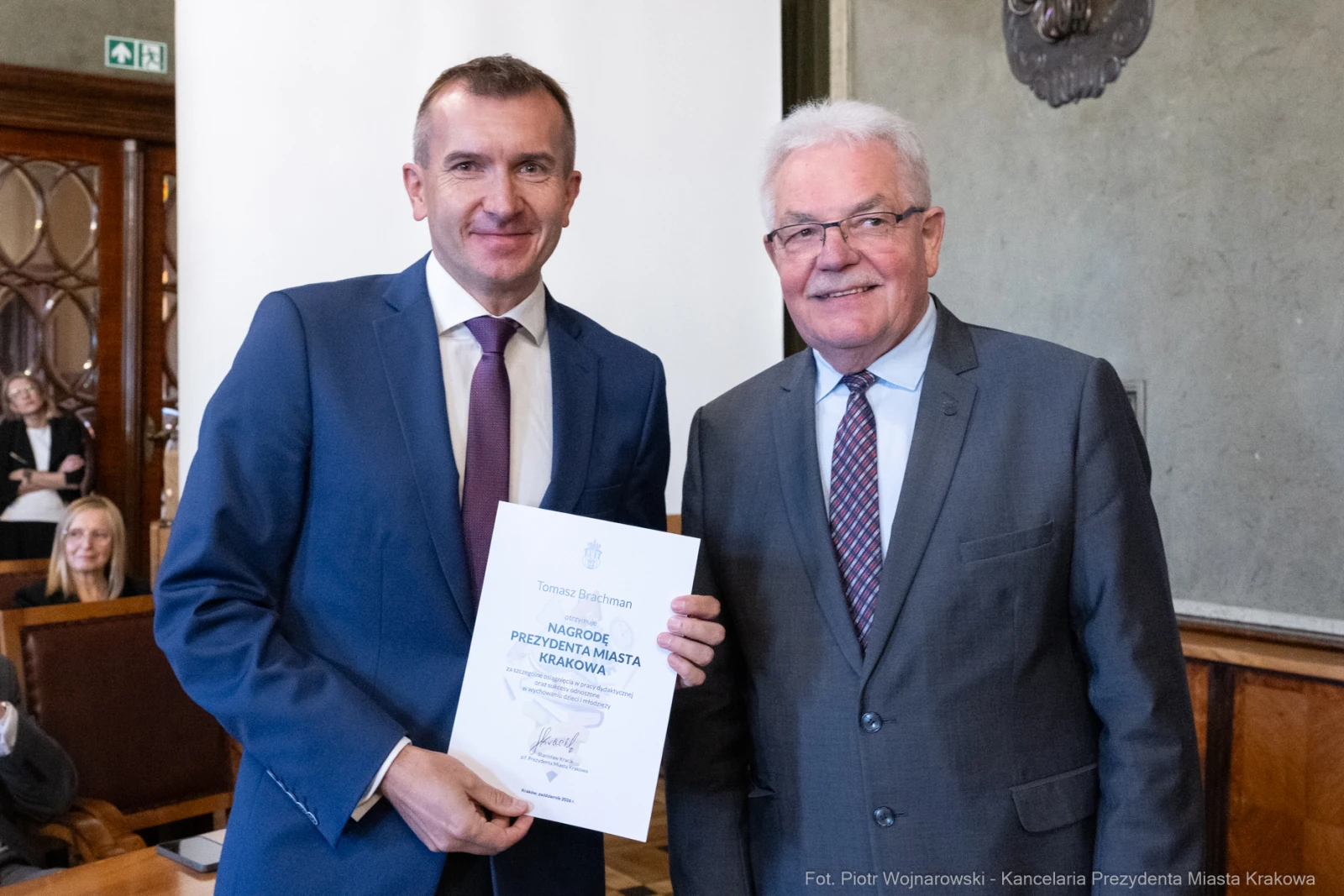 Dwaj mężczyźni trzymają dyplom w sali urzędowej.  Autor: Piotr Wojnarowski