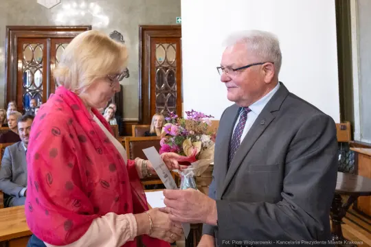 Wręczenie kwiatów i dyplomu podczas uroczystości w sali obrad.