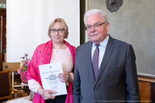Wręczenie nagrody Prezydenta Miasta Krakowa. Dwie osoby z dyplomem w ręku.