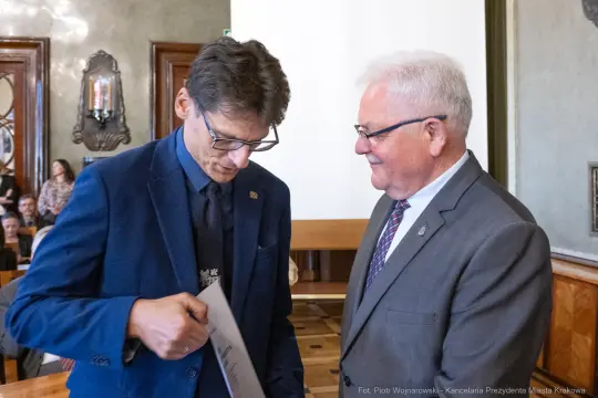 Mężczyźni w garniturach podczas ceremonii wręczenia nagrody.