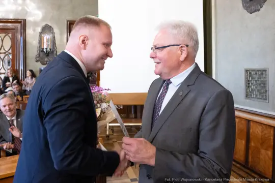 Uroczystość wręczenia nagrody, dwóch mężczyzn uścisnęło sobie dłonie.