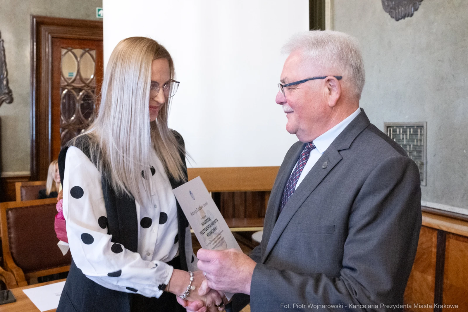 Wręczenie dyplomu przez mężczyznę kobiecie w sali konferencyjnej.  Autor: Piotr Wojnarowski