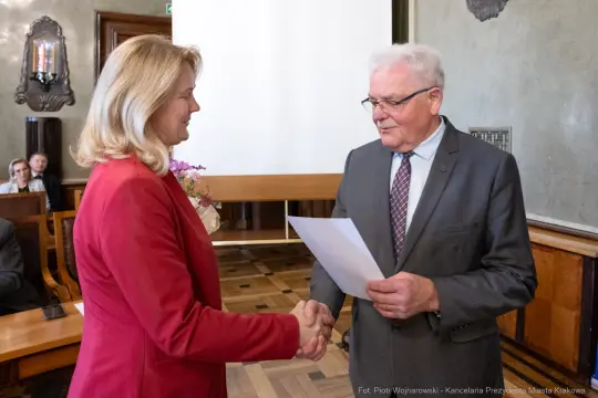 Wręczenie dokumentu podczas ceremonii w urzędzie miejskim.