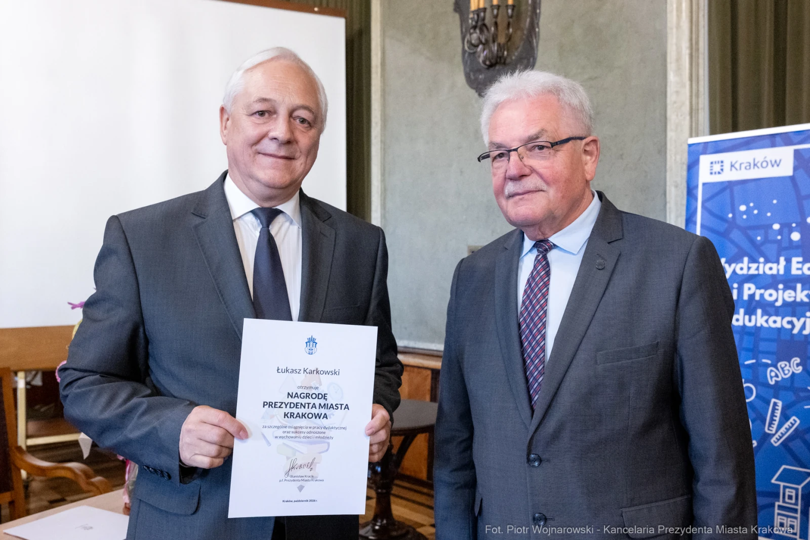 Dwóch mężczyzn trzyma dyplom nagrody prezydenta miasta Krakowa.  Autor: Piotr Wojnarowski