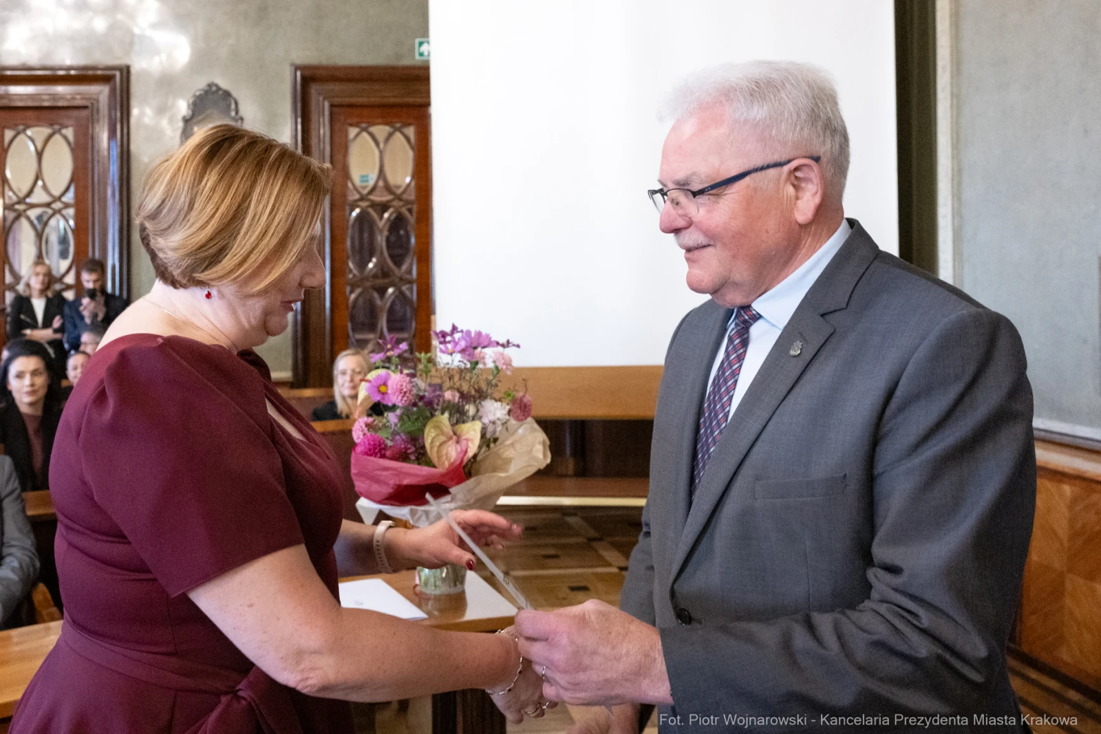 Wręczenie nagrody z bukietem kwiatów w sali urzędowej.  Autor: Piotr Wojnarowski