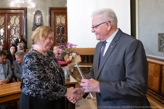 Uroczystość wręczenia kwiatów i gratulacji w sali konferencyjnej.