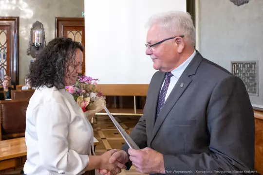 Wręczenie dyplomu z gratulacjami w uroczystej atmosferze.