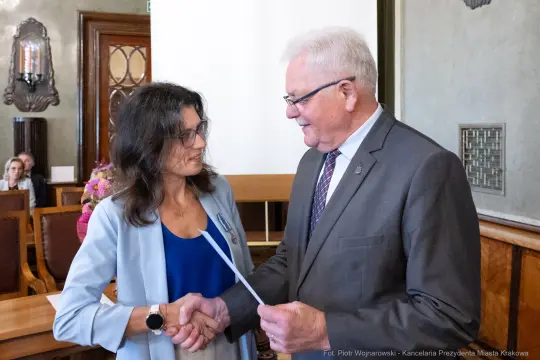 Wręczenie dokumentu podczas uroczystości w sali obrad.