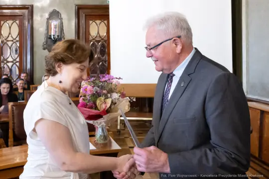 Wręczenie kwiatów i gratulacji podczas uroczystości.