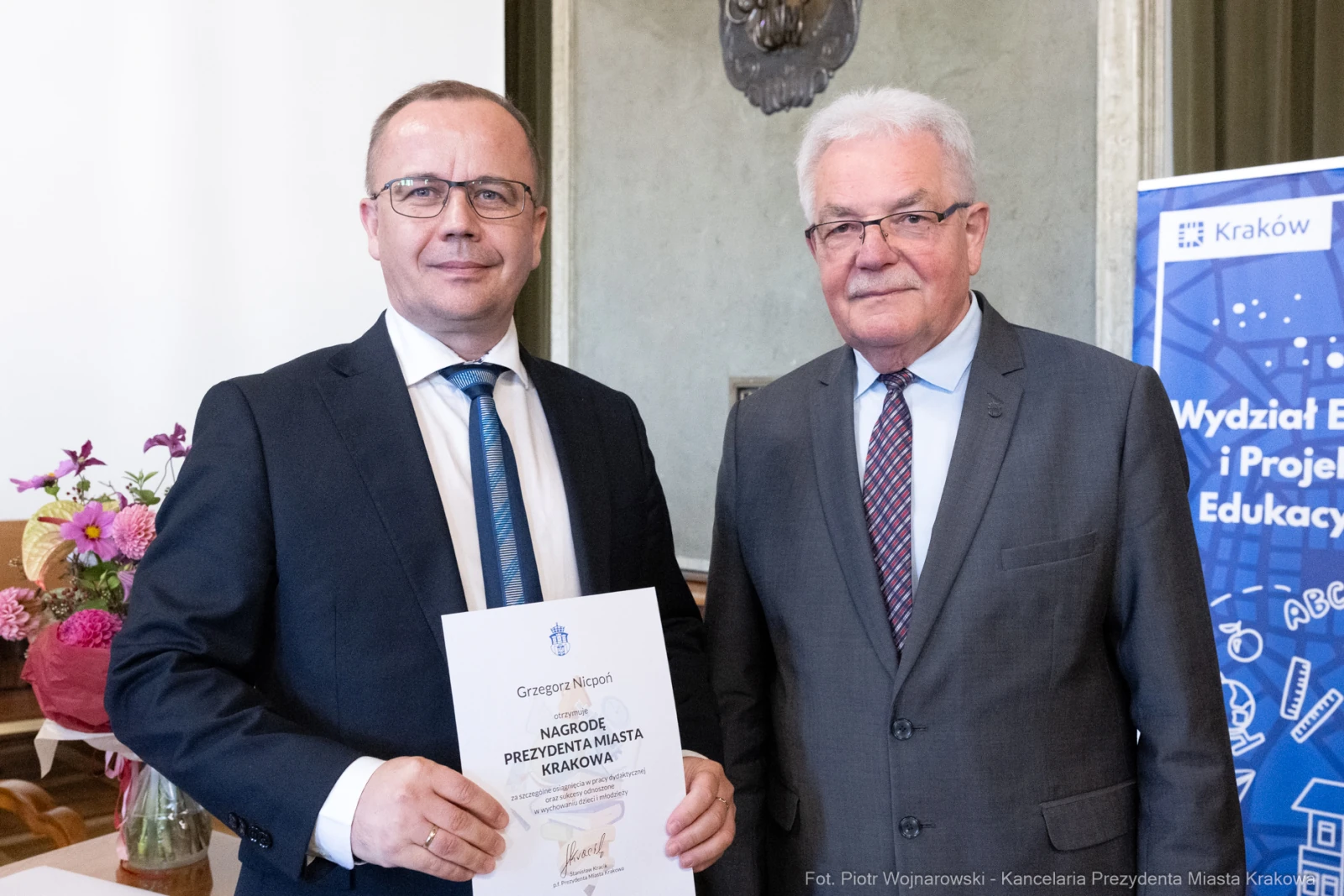 Dwaj mężczyźni trzymają dyplom nagrody Prezydenta Miasta Krakowa.  Autor: Piotr Wojnarowski