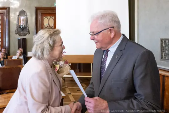 Wręczenie dyplomu podczas uroczystości w sali obrad.