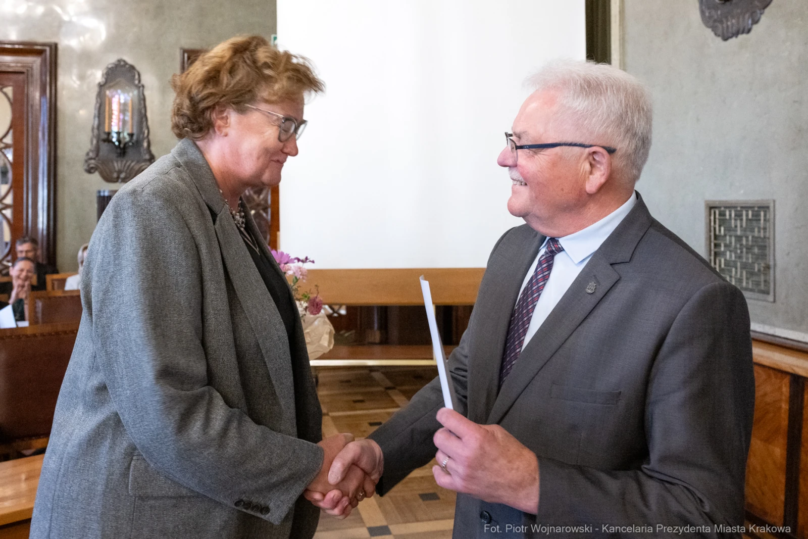 Wręczenie dyplomu podczas uroczystości w sali miejskiej.  Autor: Piotr Wojnarowski