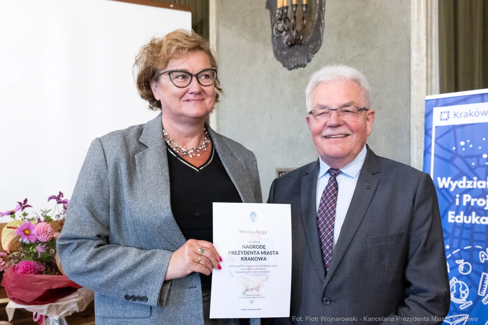 Kobieta i mężczyzna trzymają dyplom nagrody w eleganckim otoczeniu.  Autor: Piotr Wojnarowski