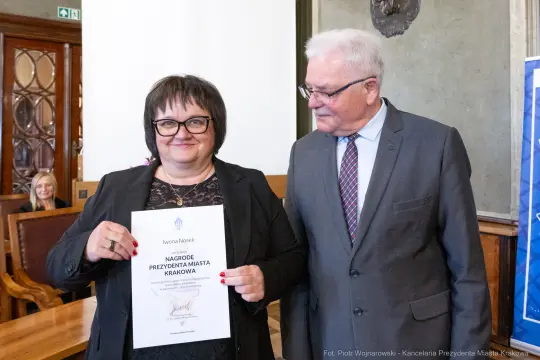Iwona Nieżyk z nagrodą Prezydenta Miasta Krakowa, obok mężczyzna w garniturze.