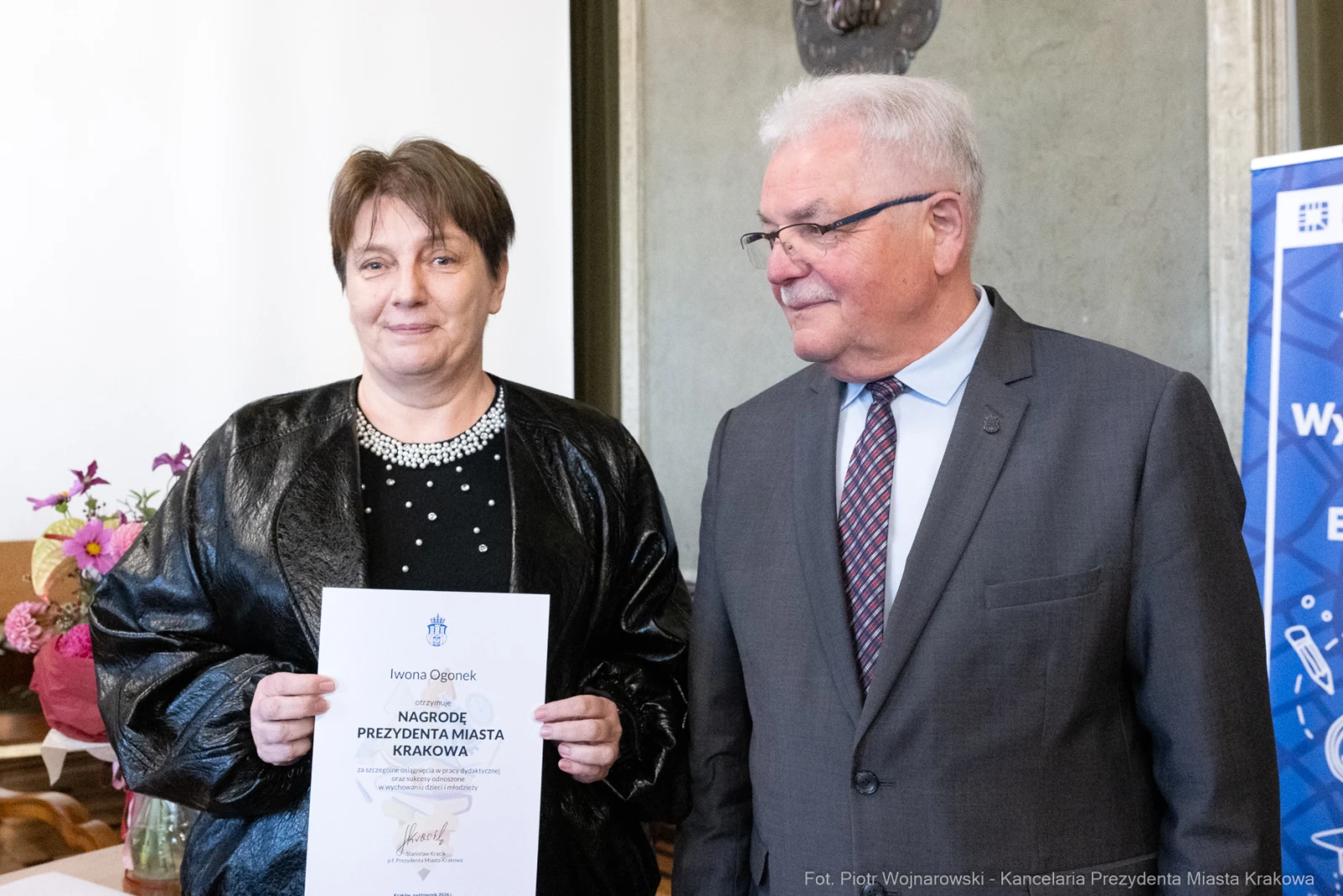 Kobieta z dyplomem i mężczyzna w garniturze, oboje uśmiechnięci.  Autor: Piotr Wojnarowski