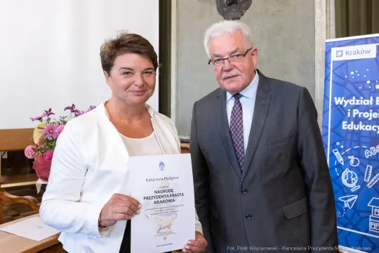 Kobieta i mężczyzna trzymają dyplom nagrody Prezydenta Miasta Krakowa.