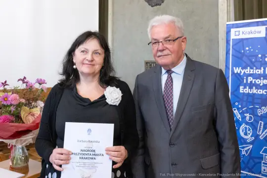 Barbarka Rasińska z nagrodą Prezydenta Miasta Krakowa, obok mężczyzna w okularach.