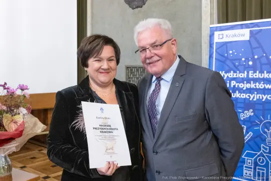Wręczenie nagrody przez prezydenta miasta Krakowa. Uśmiechnięte osoby z dyplomem.