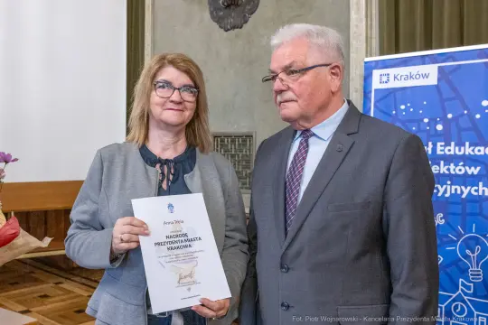 Wręczenie nagrody Prezydenta Miasta Krakowa. Dwie osoby trzymają dyplom.