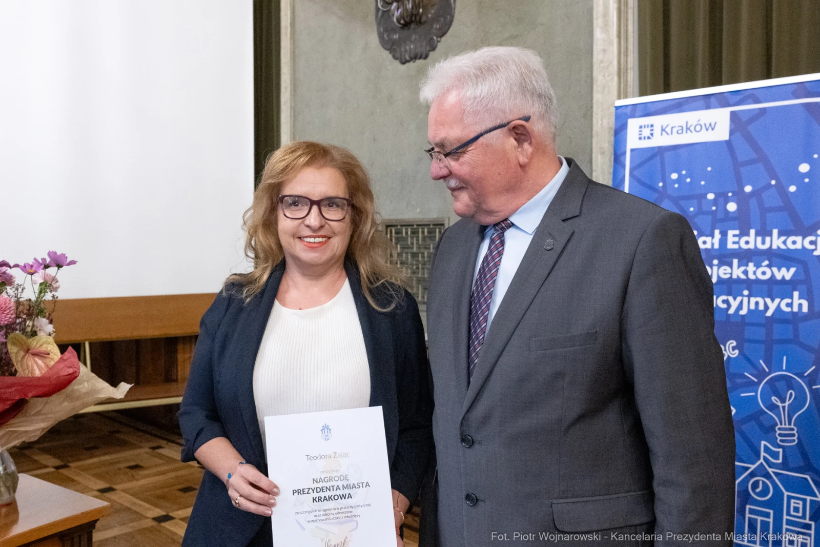 Wręczenie nagrody Prezydenta Miasta Krakowa. Uśmiechnięte osoby z dyplomem.  Autor: Piotr Wojnarowski