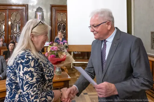 Wręczenie kwiatów i dyplomu podczas uroczystości w sali obrad.