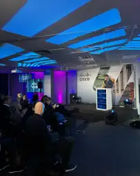 Prezentacja na konferencji Cisco z widownią i efektownym oświetleniem.