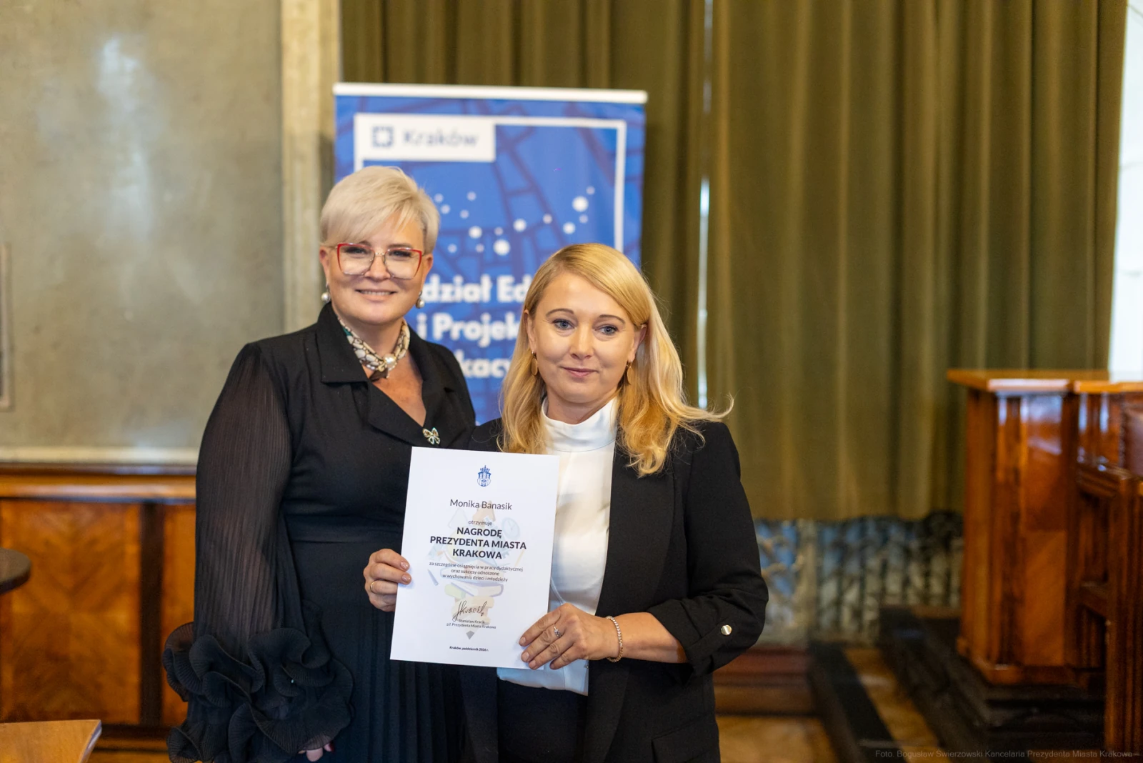 Dwie kobiety trzymają dyplom w sali z zielonymi zasłonami.  Autor: Bogusław Świerzowski