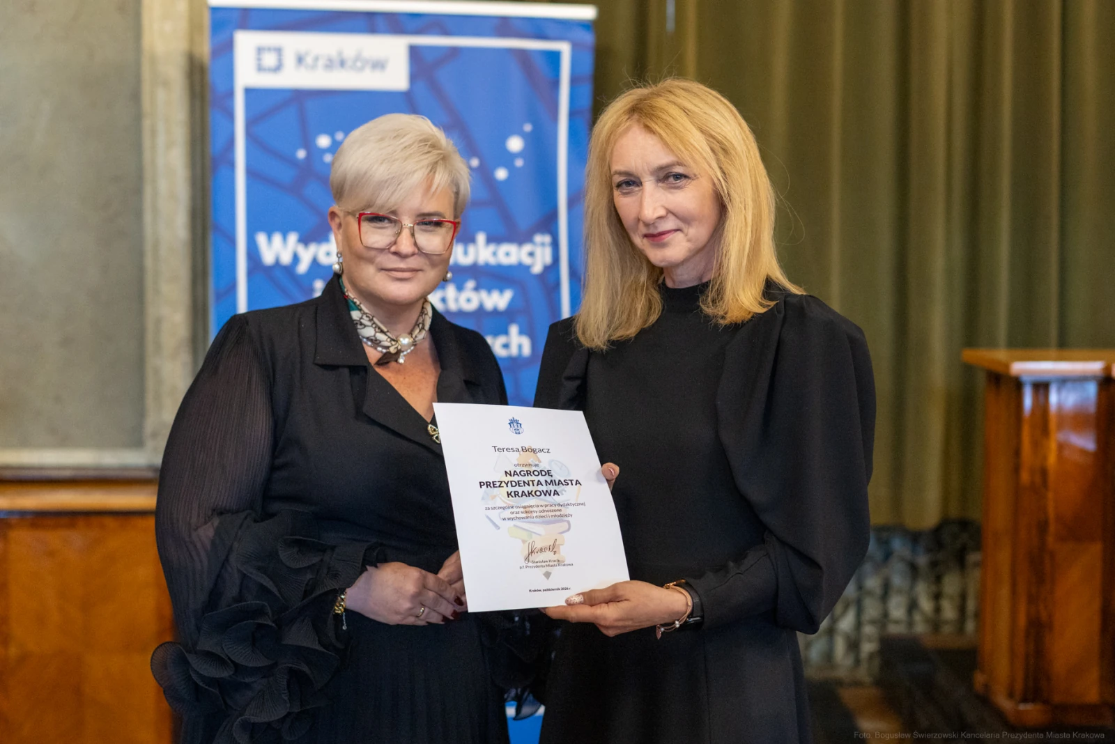 Kobiety wręczające dyplom w sali z dekoracjami.  Autor: Bogusław Świerzowski