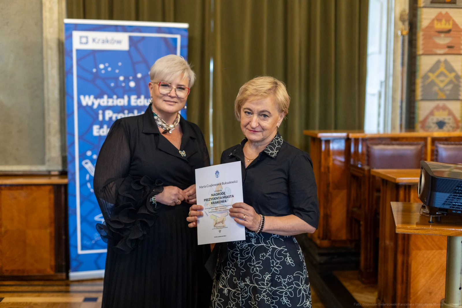 Dwie kobiety trzymają dokument w sali konferencyjnej.  Autor: Bogusław Świerzowski