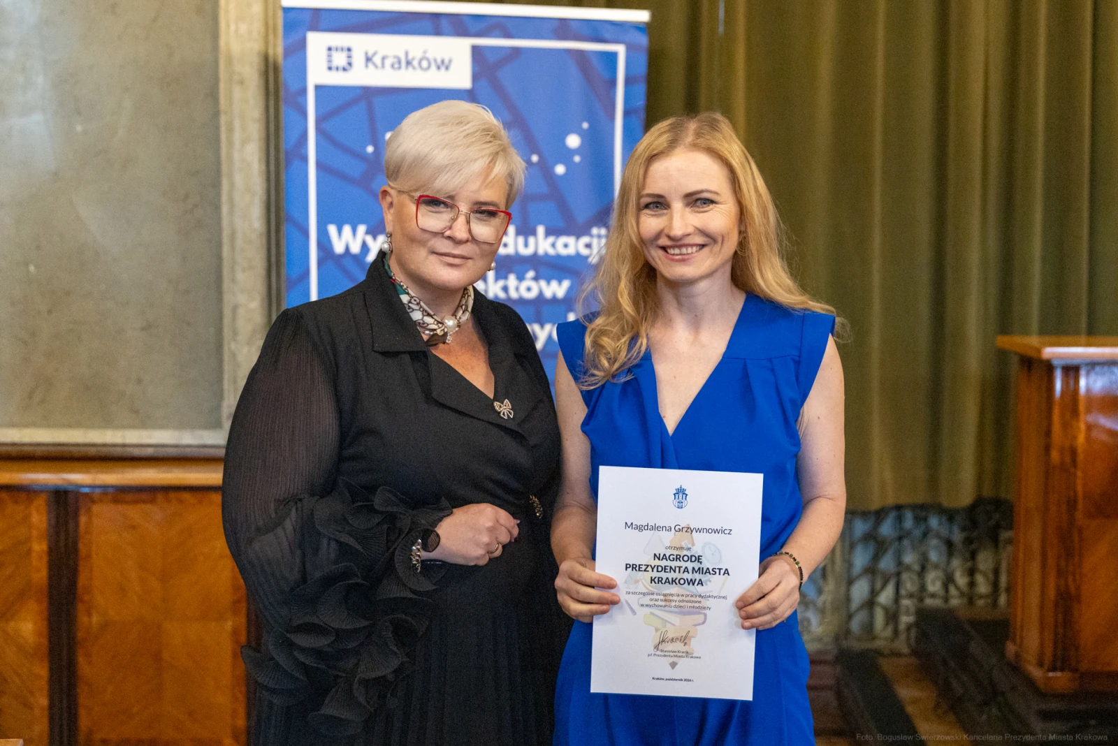Dwie kobiety trzymają dyplom w sali z zielonymi zasłonami.  Autor: Bogusław Świerzowski