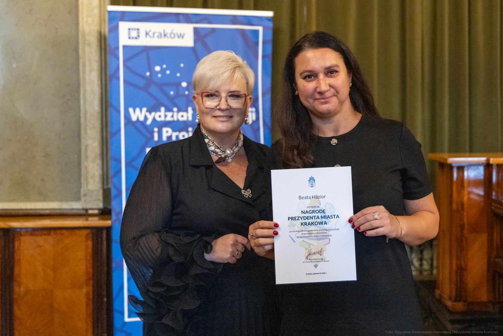 Dwie kobiety trzymają dyplom w sali z zielonymi zasłonami.  Autor: Bogusław Świerzowski