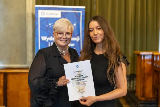 Wręczenie nagrody Prezydenta Krakowa. Dwie kobiety trzymają dyplom.
