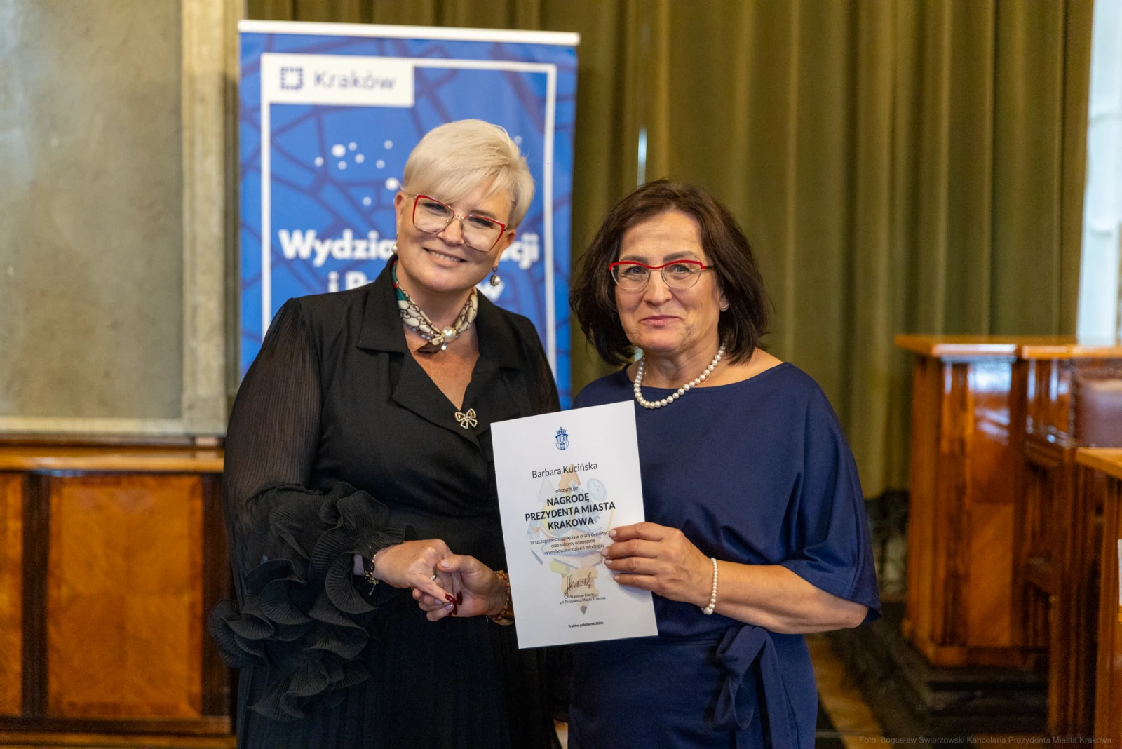 Dwie kobiety uścisnęły sobie dłonie, jedna z nich trzyma dyplom.  Autor: Bogusław Świerzowski