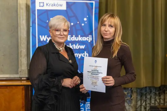 Wręczenie nagrody za prezentację w Krakowie. Dwie kobiety z dyplomem.