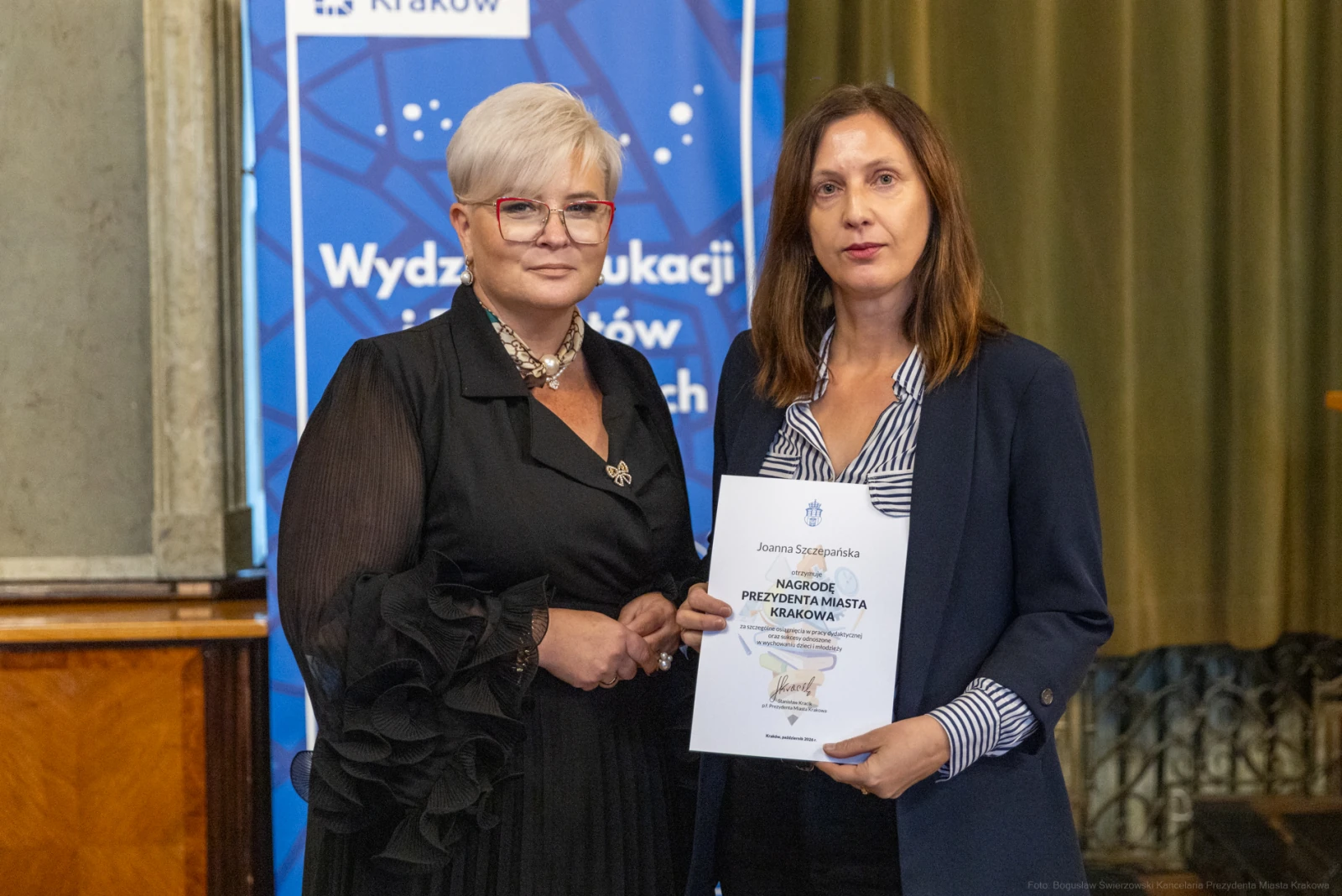 Dwie kobiety trzymające dyplom w sali z zielonymi zasłonami.  Autor: Bogusław Świerzowski