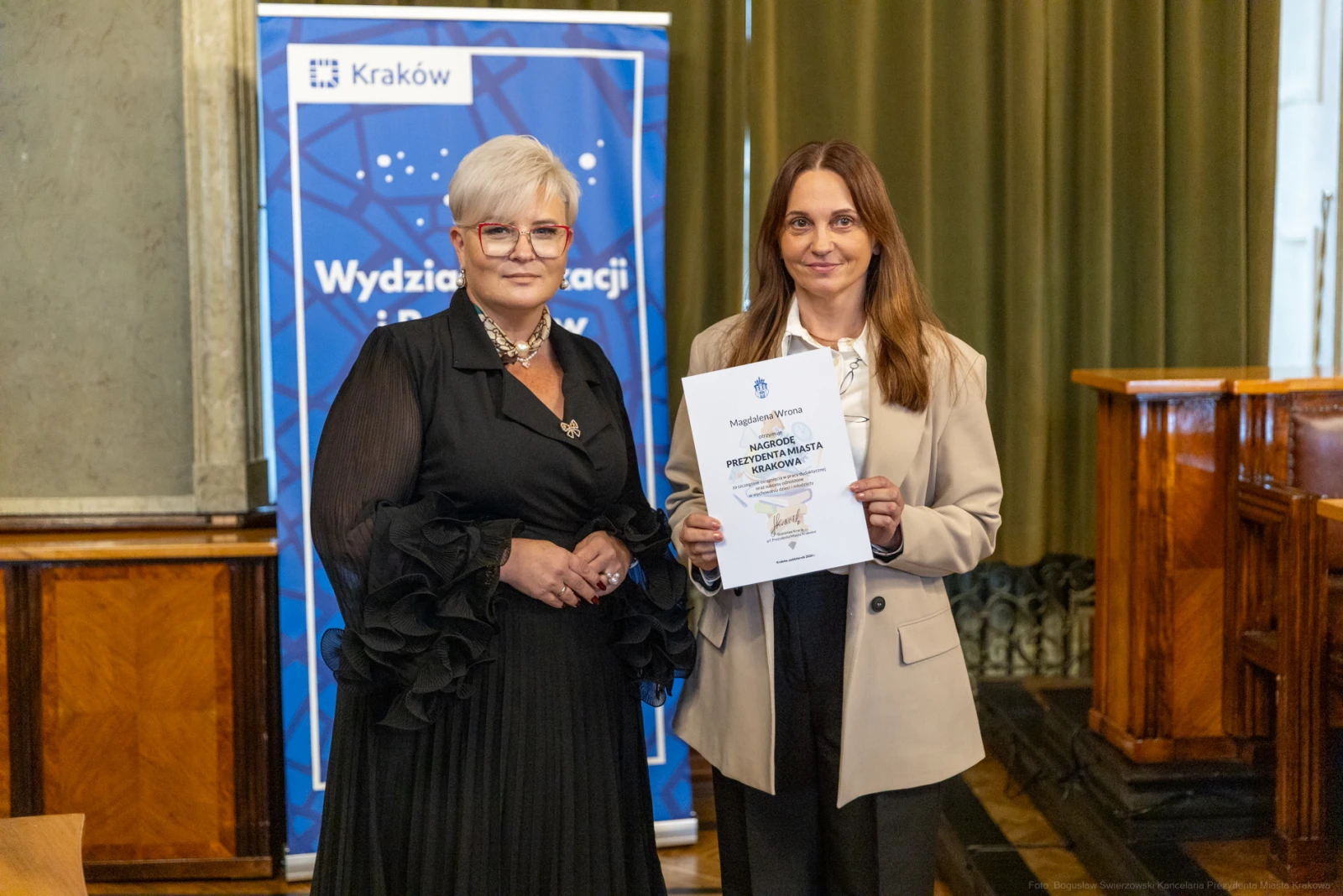 Dwie kobiety trzymające dyplom w sali z zielonymi zasłonami.  Autor: Bogusław Świerzowski