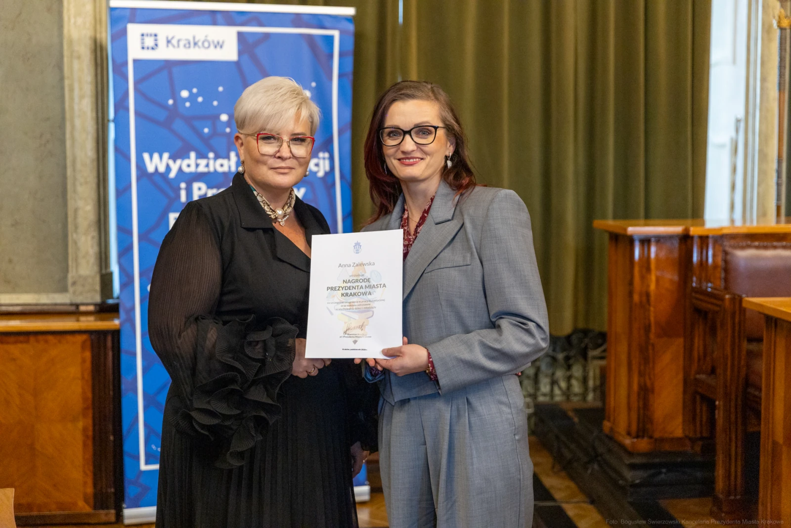 Dwie kobiety trzymające dyplom w sali z zielonymi zasłonami.  Autor: Bogusław Świerzowski
