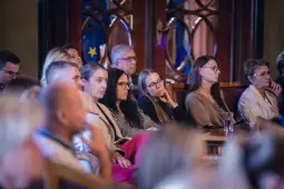 Grupa osób słuchających wykładu, skupionych na prelegencie.