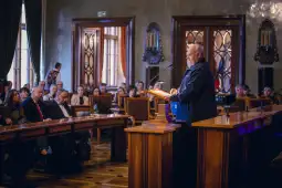 Mężczyzna przemawia do zgromadzenia w sali konferencyjnej.