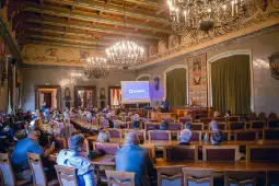 Sala konferencyjna z uczestnikami spotkania i prezentacją na ekranie.