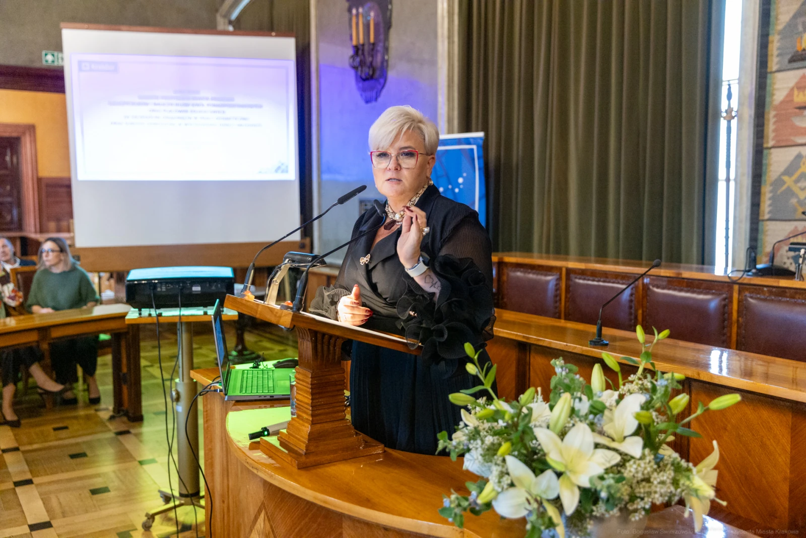 Kobieta przemawia z mównicy podczas konferencji, w tle ekran z prezentacją.  Autor: Bogusław Świerzowski