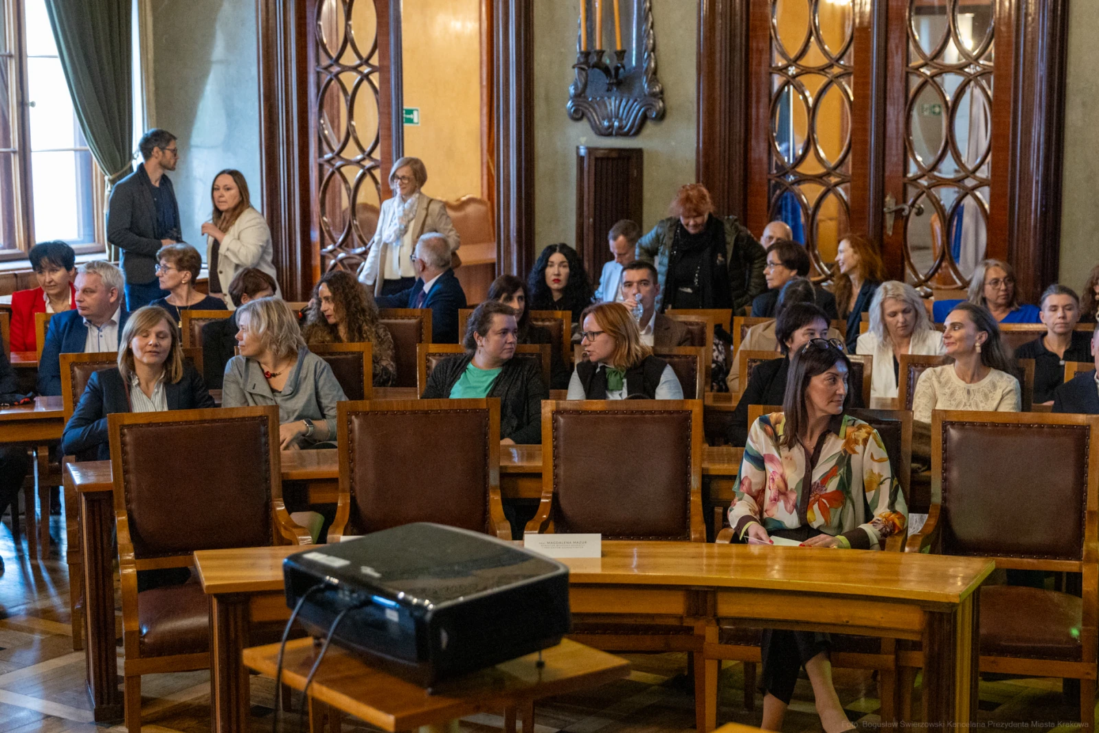 Grupa osób siedzących w sali konferencyjnej, przygotowujących się do spotkania.  Autor: Bogusław Świerzowski