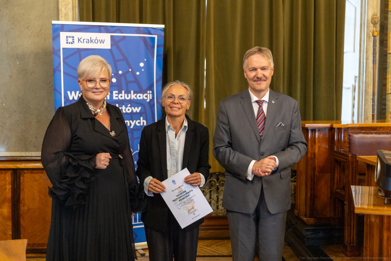 Wręczenie nagrody w dziedzinie edukacji w Krakowie, trzech osób w formalnych strojach.  Autor: Bogusław Świerzowski