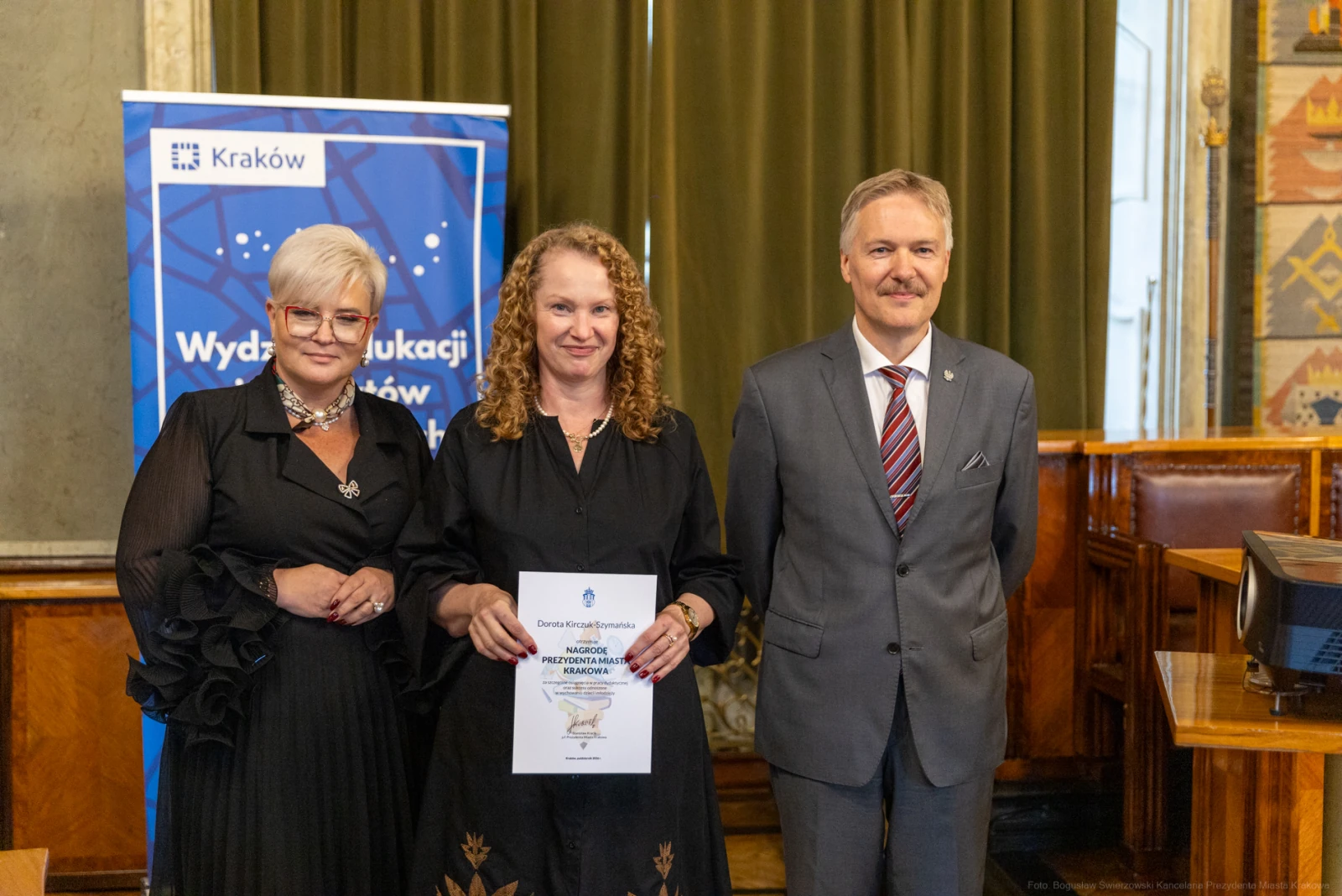 Wręczenie nagrody w Krakowie, trzy osoby pozujące z dyplomem.  Autor: Bogusław Świerzowski