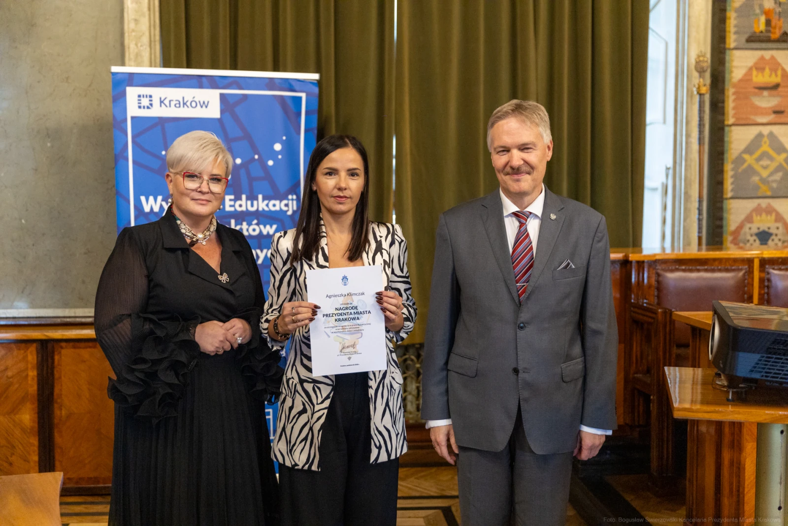 Uroczystość wręczenia nagrody w Krakowie, trzy osoby z dokumentem.  Autor: Bogusław Świerzowski