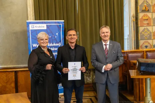 Wręczenie nagrody w Krakowie, trzej uczestnicy, dyplom w rękach laureata.