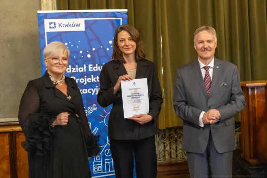 Wręczenie dyplomu w Krakowie, uczestnicy w eleganckich strojach.