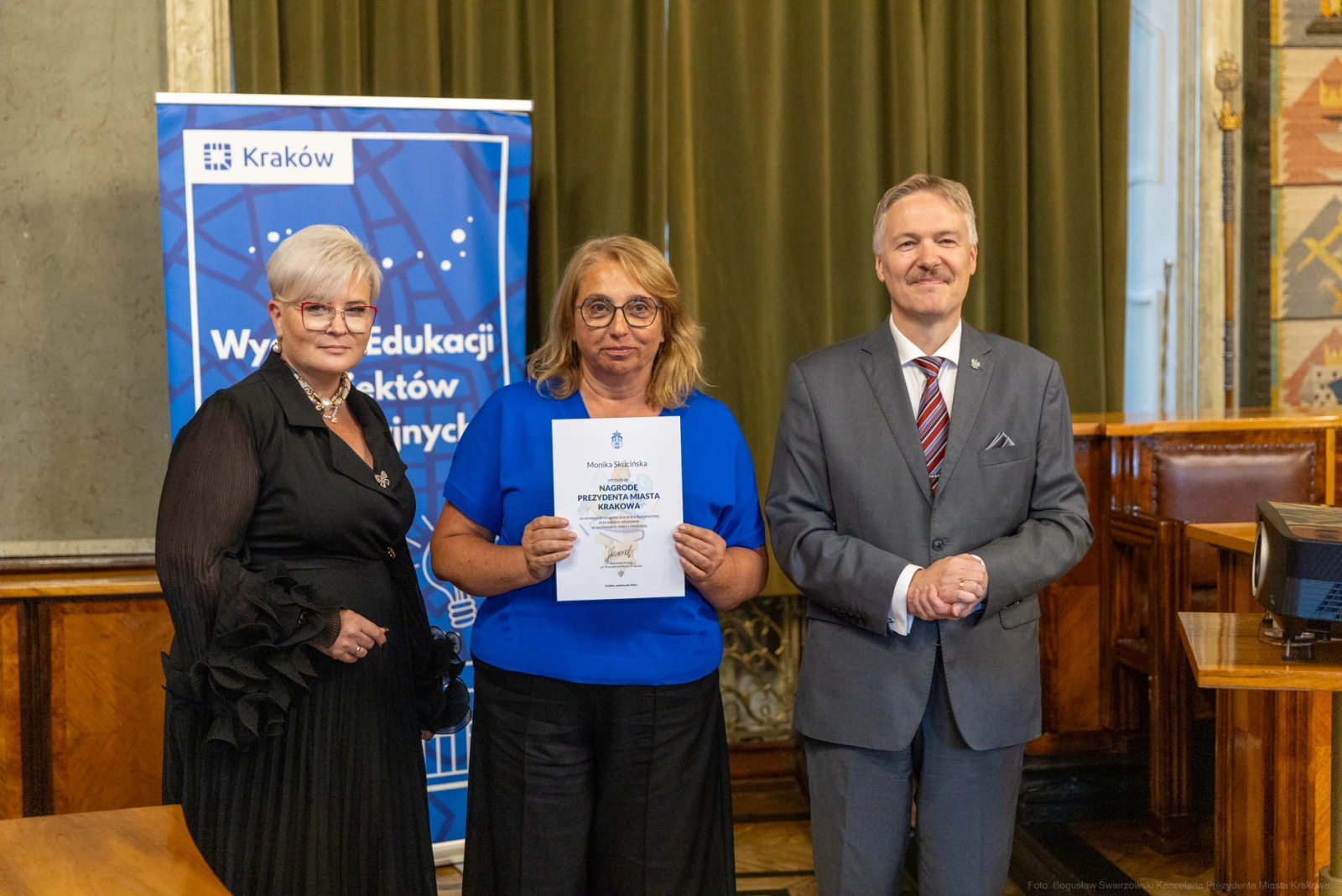 Wręczenie nagrody w Krakowie, trzy osoby pozujące z dyplomem.  Autor: Bogusław Świerzowski