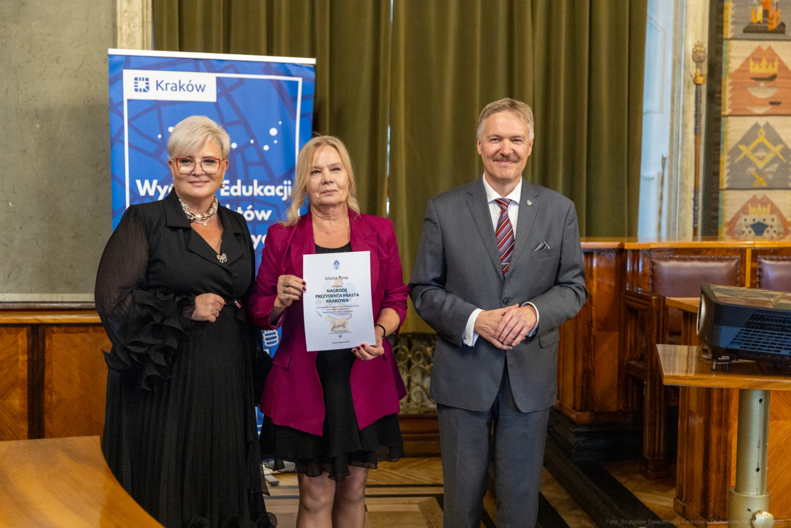 Wręczenie nagrody w Krakowie, trzy osoby pozujące z dyplomem.  Autor: Bogusław Świerzowski
